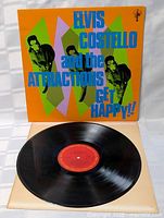 Black vinyl record LP shown out of sleeve with red center label, reflecting light to show condition.