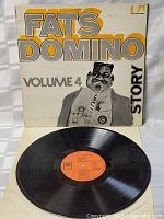 Vinyl LP record with orange label and original cover showing artist name, volume, and illustration.