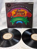 Photo of two black vinyl records placed in front of the album cover, showing the MCA Records cream label on each disc.