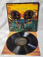 Front view of Steppenwolf 7 vinyl record LP showing the black vinyl record with label and colorful album cover featuring skull artwork and band members