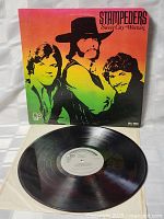 Front cover of The Stampeders Sweet City Woman album showing colorful band portrait and album title.