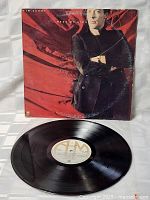 Full view of vinyl record on white fabric background showing the black LP and original label from A&M Records