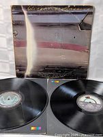 Front view of the vintage Wings Over America double LP set cover and two vinyl records placed in front.