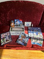 Full view of all items in the lot including calendar, figurine, player cards, and promotional merchandise on a red couch