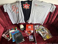 Overview of CFL memorabilia including 3 t-shirts, collector books, magazines, mini helmet, trading cards and poster tube.