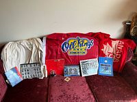 Full overview of hockey memorabilia including shirts, flags, collectibles, and framed photos on red couch.