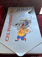 Lightly worn white box with a cartoon football player and mascot, labeled 'Jogo 1991 CFL Football'.