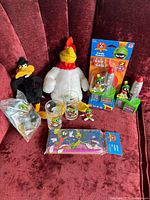 Full collection showing plush toys (Foghorn Leghorn, Daffy Duck), drinking glasses with Marvin the Martian, Marvin figurines and candy dispensers in original packaging.