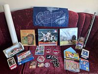 Photo taken showing wide array of baseball memorabilia on a red couch including patches, books, cards, posters, and figurines.
