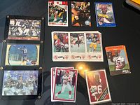 Photo showing framed and multiple loose football trading cards including Randy Moss and CFL players