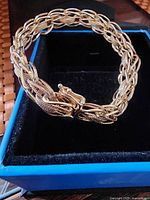 Bracelet placed in box showing full braided chain and clasp