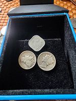 Coins in black case with 1 paisa India coin and two US Mercury dimes showing obverse sides.