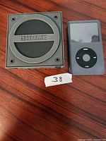 Photo showing the iHome branded portable speaker and black iPod Classic on a wooden surface.