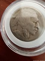 Obverse side of the coin showing profile of Native American, worn condition and unreadable date.