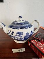 Side view of the blue and white Johnson Bros England teapot and three small Fen Shu books