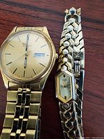 Men's Seiko and women's Citizen watches side by side showing full watches and bracelets
