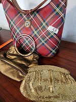 Three vintage purses: a large plaid handbag, a small gold fabric purse, and a gold mesh evening bag laid out on a wooden surface.