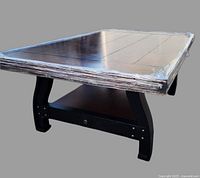 Side angle showing the sturdy wooden legs, lower shelf with drawer, and rectangular top with visible wood grain.