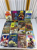 Full view of the comic book collection laid out showing 16 comic books from series including Hero Sandwich, Planet of the Apes, The Terminator, Dalgoda, The Lost World, Blood of the Innocent, The Humans, Luger, The Dreamery, Winter World