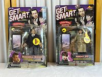 Two unopened action figures of Maxwell Smart and Agent 99 in original blister card packaging with visible aging and damage to boxes.