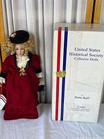 Full view of the porcelain collector doll standing beside the original box showing United States Historical Society Collector Dolls branding with artist name Bette Ball and Goebel manufacturer details.