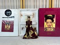 Porcelain Barbie Holiday Ball collector doll displayed outside original box, showing burgundy gown with gold embroidery and accessories in styrofoam insert.