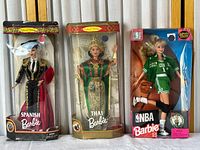 Full view of three Barbie dolls in original packaging: Spanish Barbie, Thai Barbie, and NBA Boston Celtics Barbie.