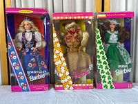 Front view of three boxed Barbie Dolls of the World Collection: Norwegian, Australian, and Irish Barbies displayed side by side on a table.