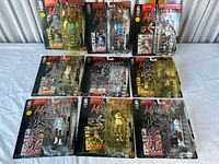 Nine sealed Michael Jordan collectible figures in original packaging laid out on a white surface, showing various poses and uniforms.