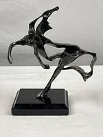 Front view of the abstract metal horse sculpture showing dynamic form and base