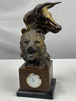 Full front view of brass-tone bull and bear sculpture on base with clock insert