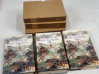 Photo showing all three volumes of "A Dream of Red Mansions" books with their dust covers laid out in front of the decorative slipcases.