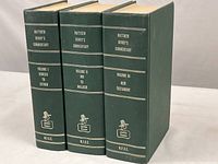 Three hardcover volumes with green covers standing upright, showing spines with titles and volume numbers.