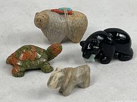 Photo of all four carved stone fetishes together showing variety and size relations