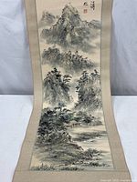 Full view of the entire scroll showing the mountain landscape artwork and fabric backing.