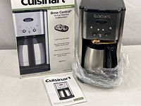 Cuisinart coffee maker with box and instruction manual showing front and side views