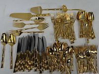 Flatware pieces arranged by type illustrating gold tone finish and bamboo motif on handles