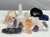 Full view of all mineral specimens on white background showing various crystal points, clusters, and polished stones.