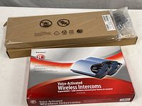 A photo showing the Radio Shack wireless intercoms box and the long brown box containing the Lenovo wireless keyboard.