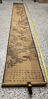 Full length view of the 12-foot hand-painted Chinese scroll laid flat with measuring tape showing length.