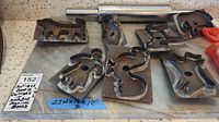 View of whole lot showing 9 metal animal and human shaped antique cookie cutters, metal rolling pin with stainless steel handles, and rectangular marble baking board.