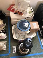 Wide view showing Zojirushi bread maker, Kitchen Aid roasting pan with lid, West Bend slicing guide, Crock Pot, Hamilton Beach bar mixer, and other small kitchen items.