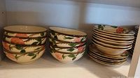 Stacked soup bowls with pink and orange rose pattern and green leaves on cream ceramic with brown trim.
