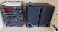 Front view of the JVC compact component system stacked with two speakers and remote on top.