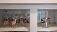 Seven tall Franciscan Desert Rose iced tea glasses decorated with multiple pink rose flowers and green leaves.