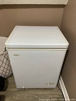 White Danby chest freezer front view showing closed lid and control knob.