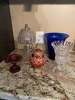 Full view of all five pieces on a countertop showcasing lamp, three vases, and a decorative dish.
