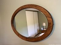 Front view of the round wall mirror showing the wooden frame and clear reflective surface.