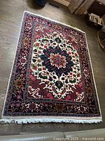 Full view of rectangular multicolor Persian rug on wooden floor showing central medallion and borders.