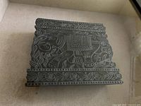 Front view of the stone woodblock art showing detailed elephant and floral carvings in relief with floral border.